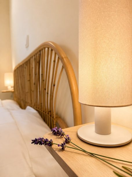 Sfeervol bed met rieten hoofdbord en lamp, versierd met lavendel.